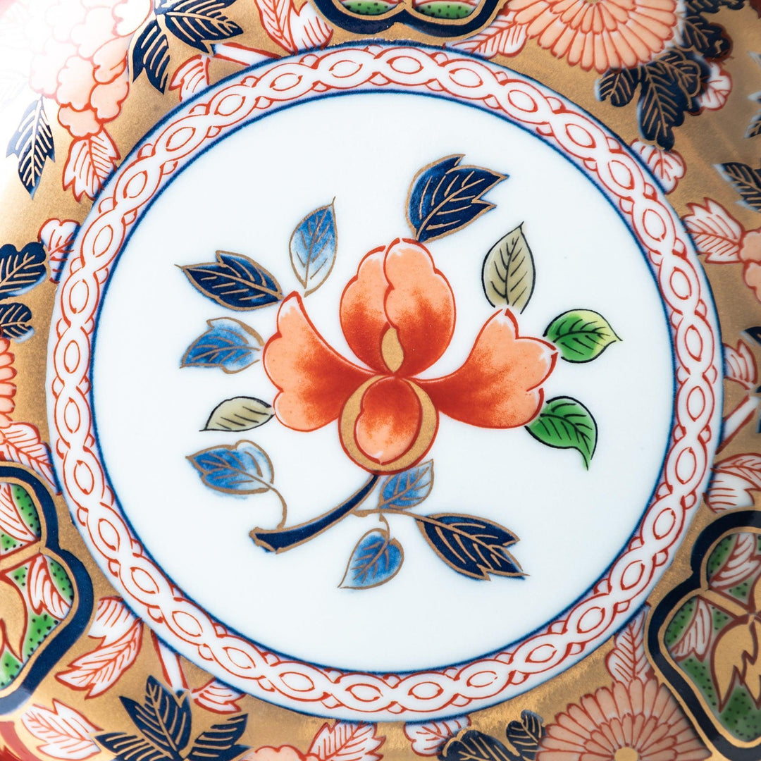 Dessert plate with central floral motif bordered by multicolored patterns and gold blue traditional designs.