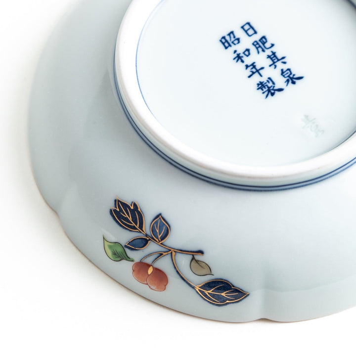 Dessert plate with central floral motif bordered by multicolored patterns and gold blue traditional designs.