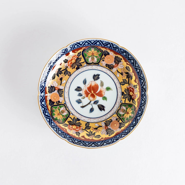 Floral salad plate with gold detailing and red flower center surrounded by green blue and gold patterns.