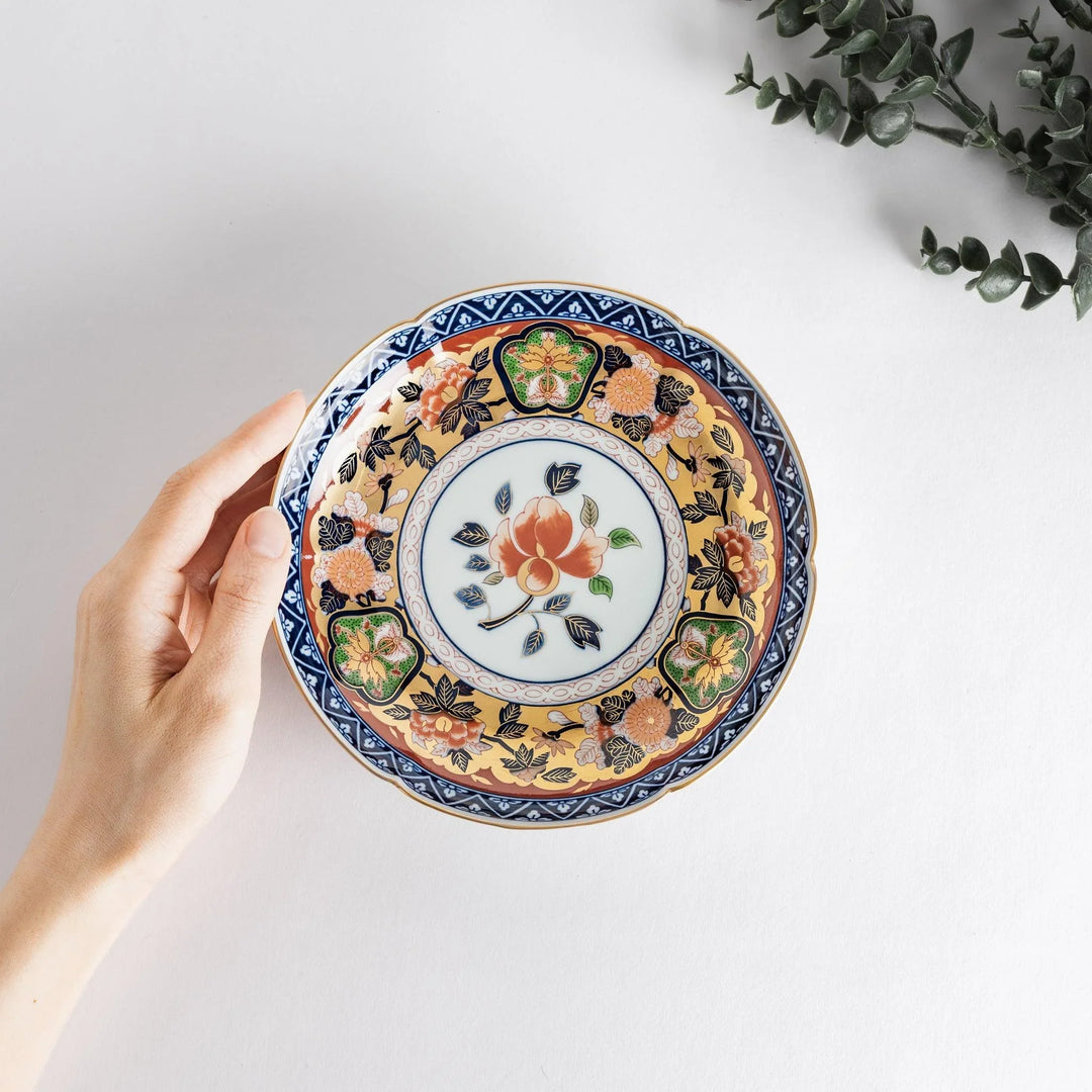 Floral salad plate with gold detailing and red flower center surrounded by green blue and gold patterns.
