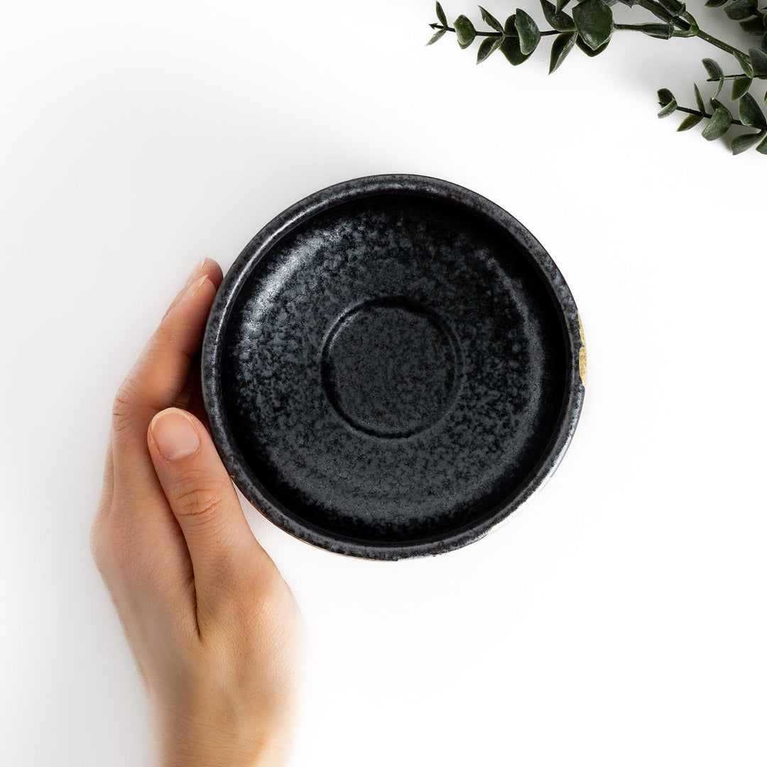 Matcha Bowl featuring a beautiful gold leaf and plum blossom design, set against a dark, textured background.