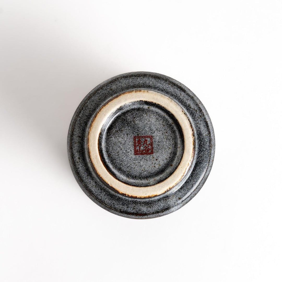 Gray ceramic teacup with gold and pastel floral pattern speckled glaze and flared rim for elegance.