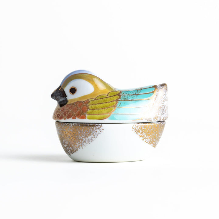 A small condiment bowl shaped like a hen, featuring a detailed painted design with blue, green, and gold accents.