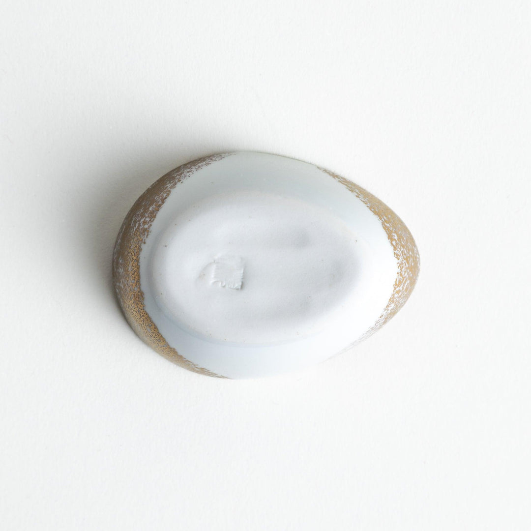 A small condiment bowl shaped like a hen, featuring a detailed painted design with blue, green, and gold accents.