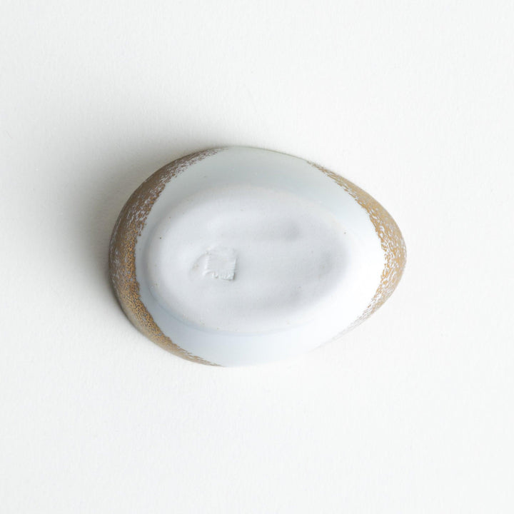 A small condiment bowl shaped like a hen, featuring a detailed painted design with blue, green, and gold accents.