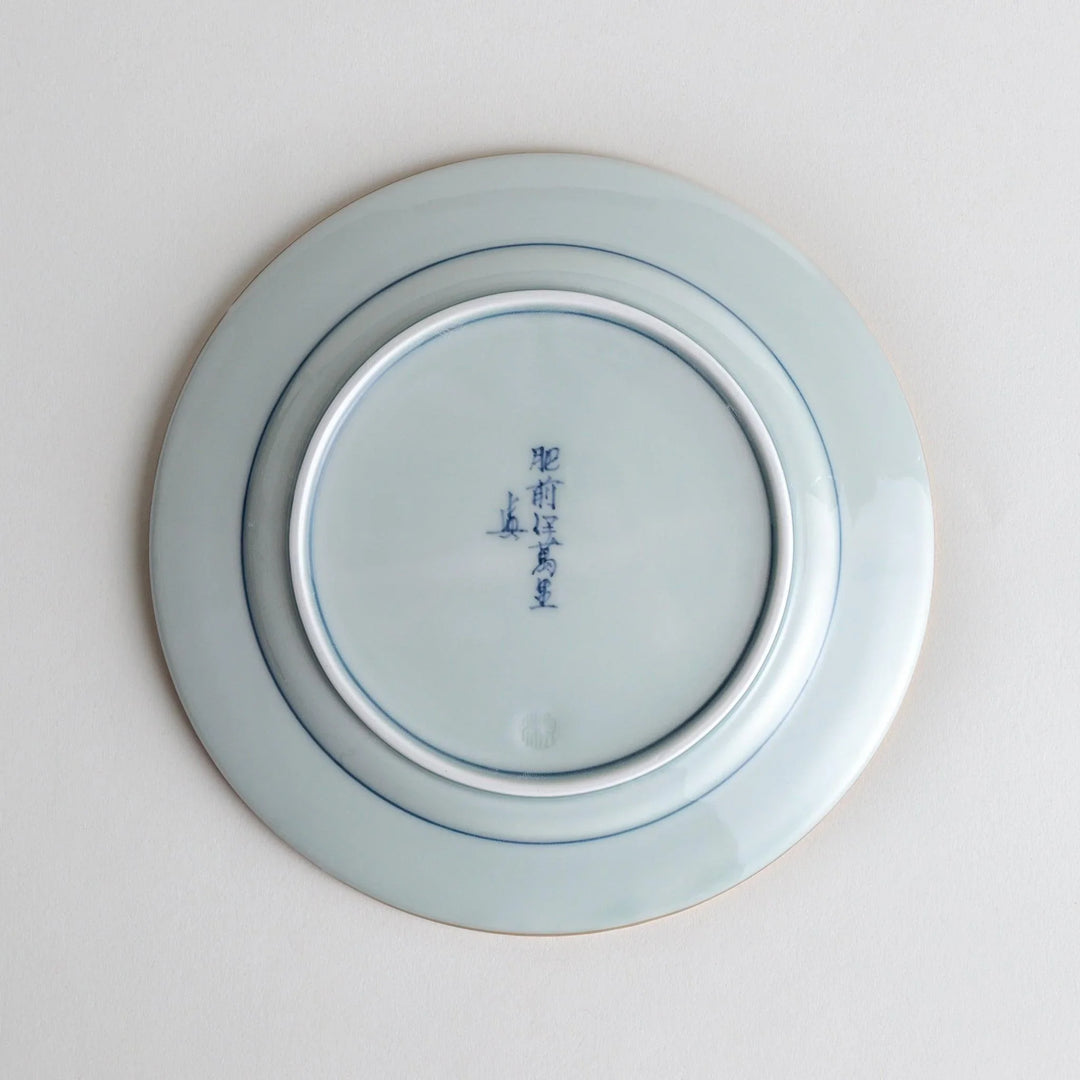 Japanese Imari style porcelain plate with central floral motif and ornate red blue and gold rim pattern.