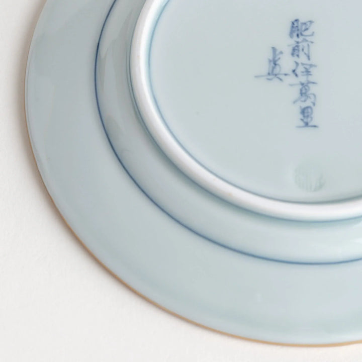 Small Japanese porcelain plate with Imari style floral design and alternating red blue and gold patterns.