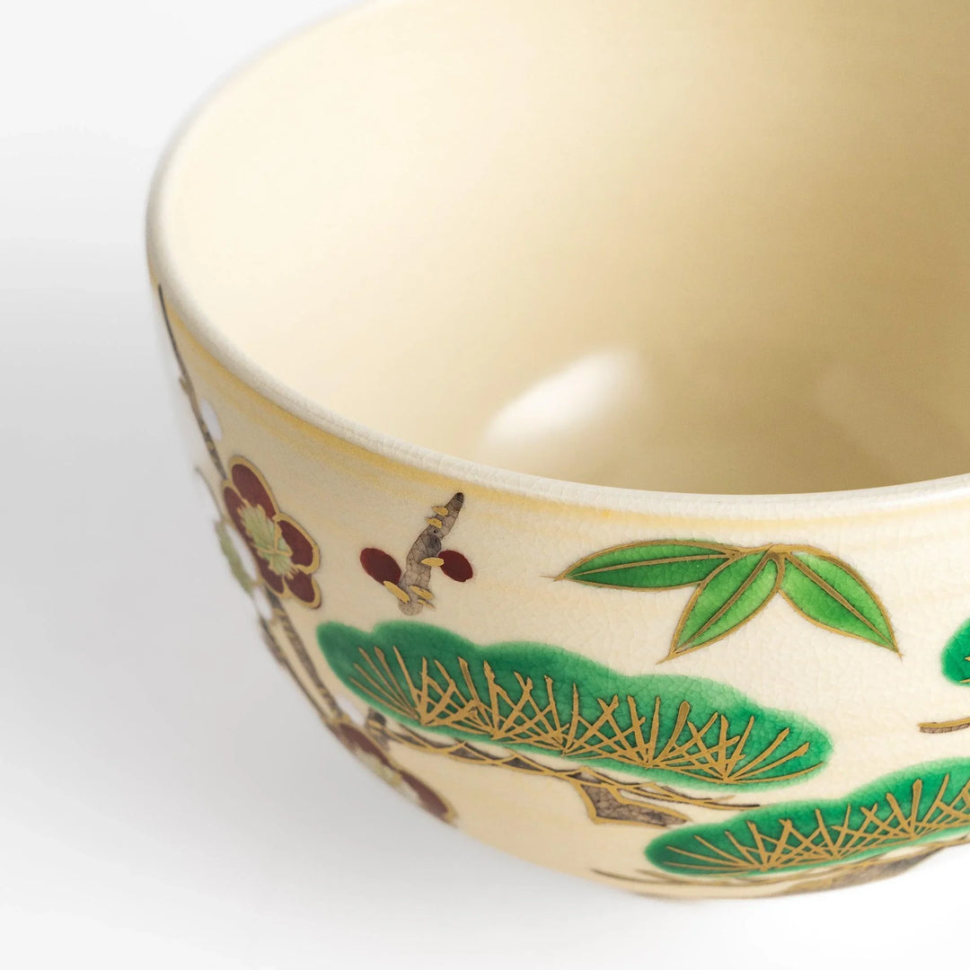 Golden Pine, Bamboo, and Plum Matcha Bowl with green, gold, and red motifs, perfect for an elegant tea experience.