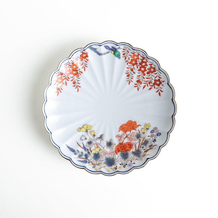 Round scalloped salad plate with floral designs in red yellow and blue and wisteria branch at the top.