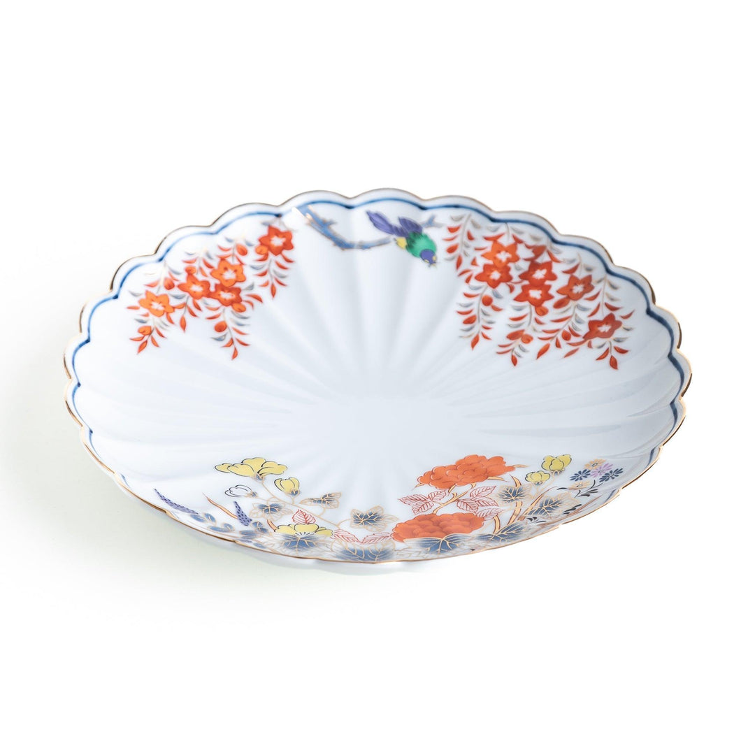 Round scalloped salad plate with floral designs in red yellow and blue and wisteria branch at the top.