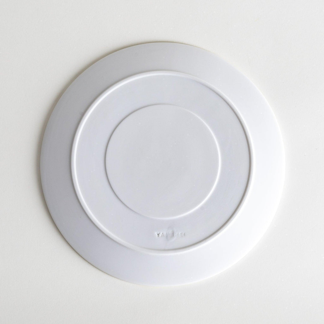 A white salad plate featuring a unique bubble design in shades of blue, resembling frothy ocean waves.