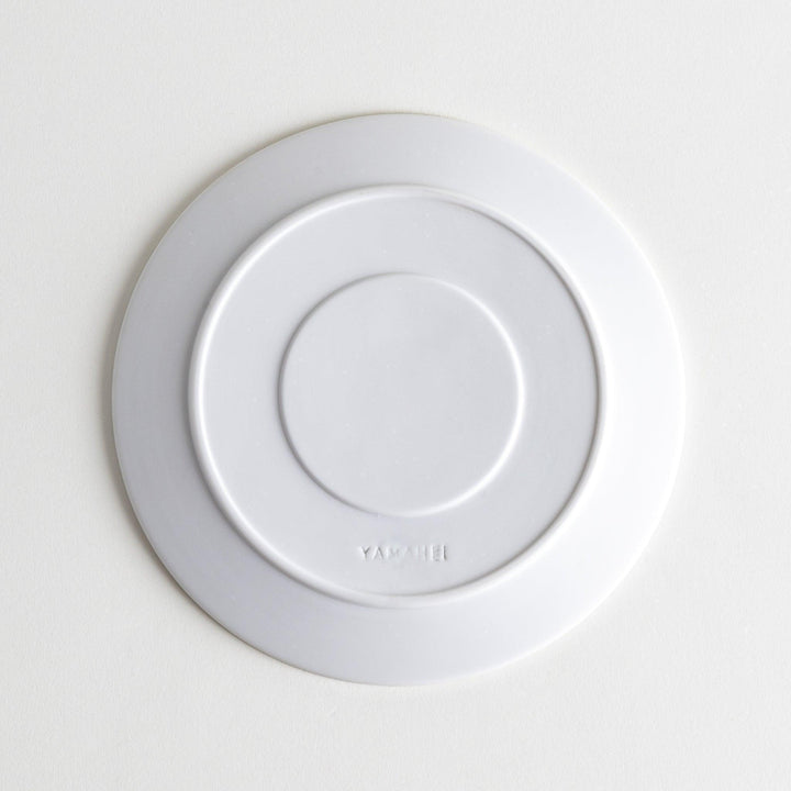 A white dessert plate featuring a unique bubble design in shades of blue, resembling frothy ocean waves.