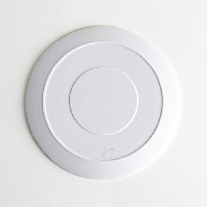 A white dinner plate featuring a unique bubble design in shades of blue, resembling frothy ocean waves.