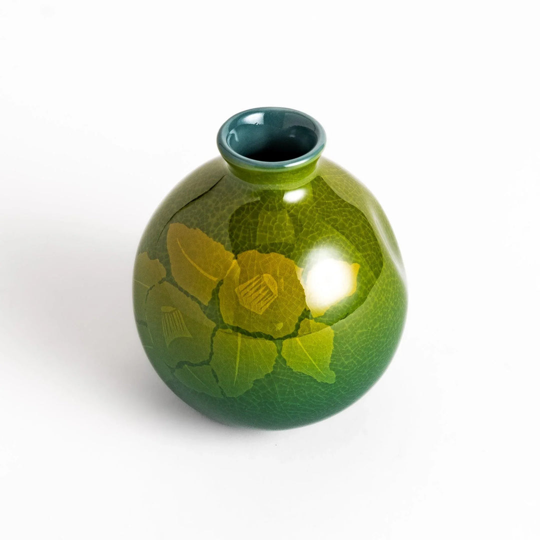 Green ceramic sake carafe with a subtle leaf pattern and a unique crackled glaze, perfect for serving sake in style.