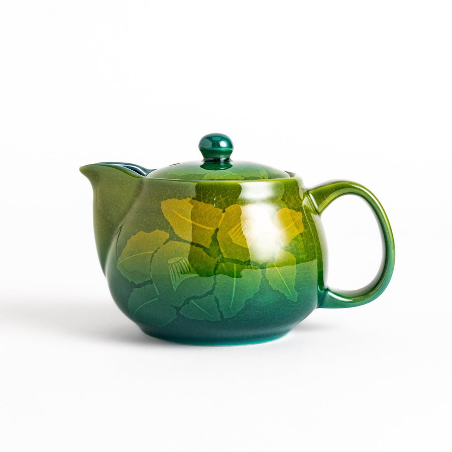 Glossy green ceramic teapot with gradient leaf design and secure lid ideal for everyday tea serving.