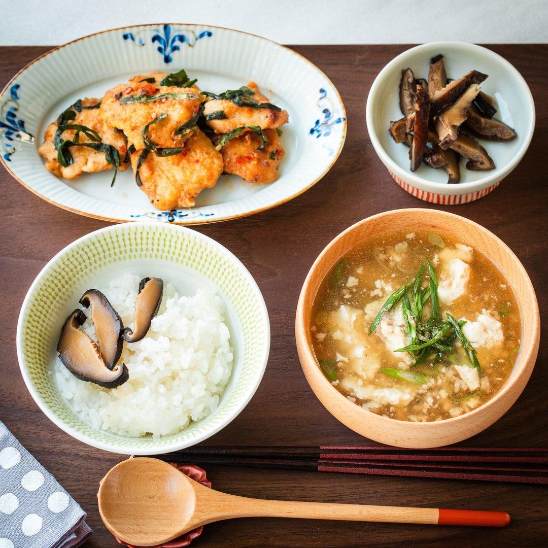 Japanese ceramic tableware with floral plate green rice bowl and wooden tofu soup bowl for homestyle dining.