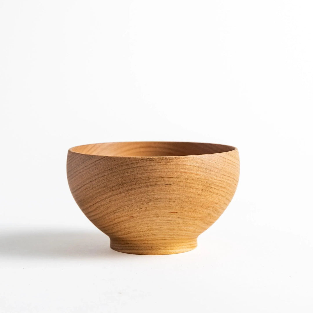 Smooth cherry wood bowl with visible grain and simple elegant design displayed on white background.