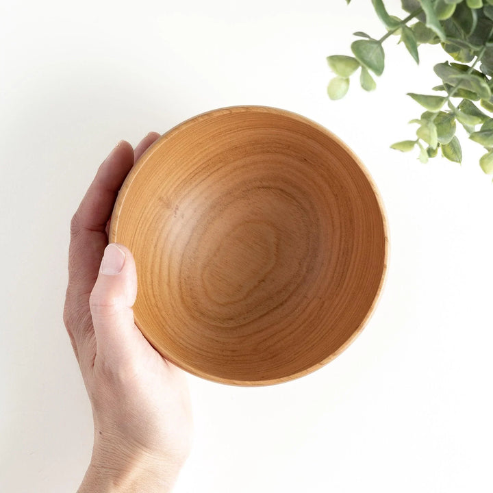 Smooth cherry wood bowl with visible grain and simple elegant design displayed on white background.