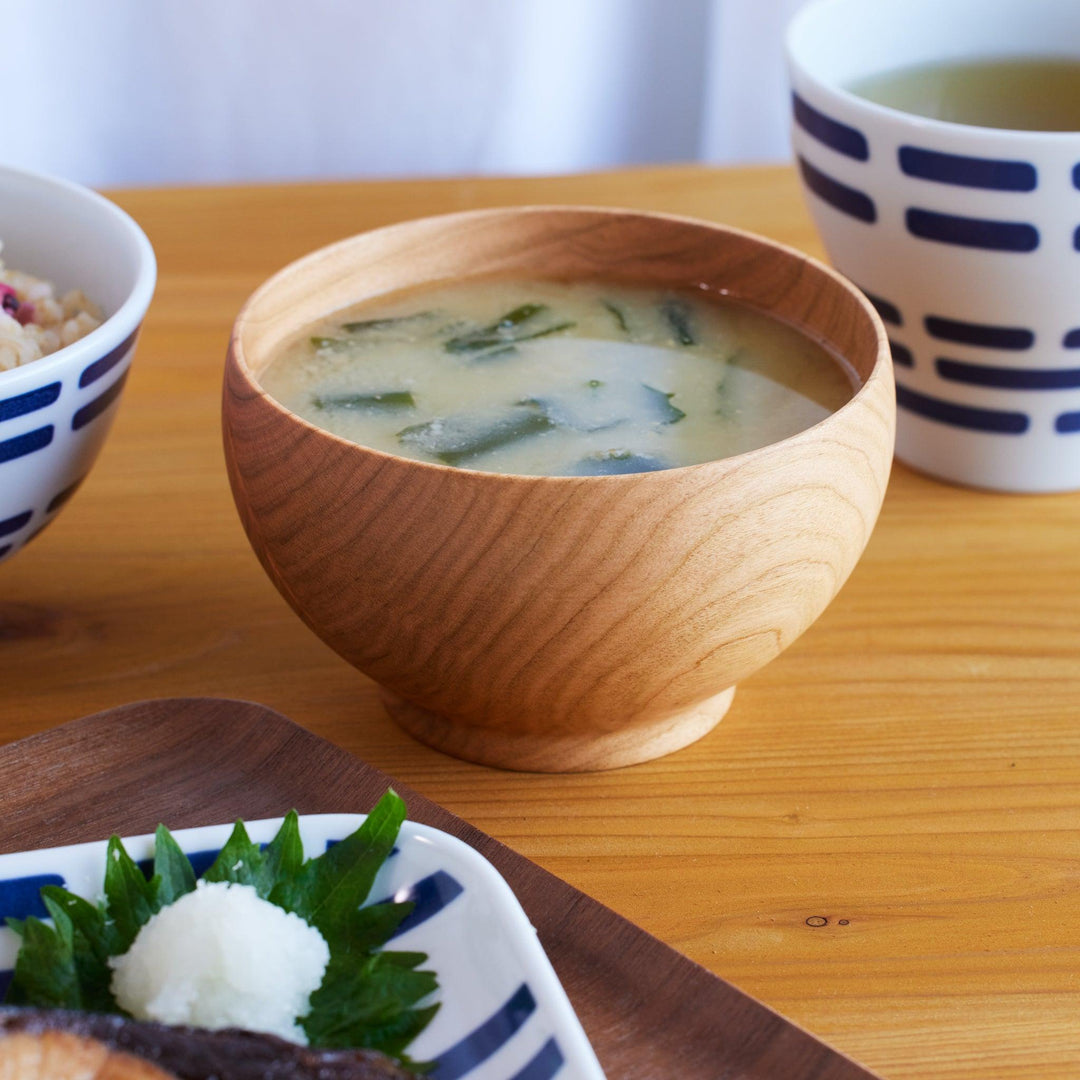 A medium-sized miso soup bowl made from handcrafted cherry wood, filled with seaweed miso soup.