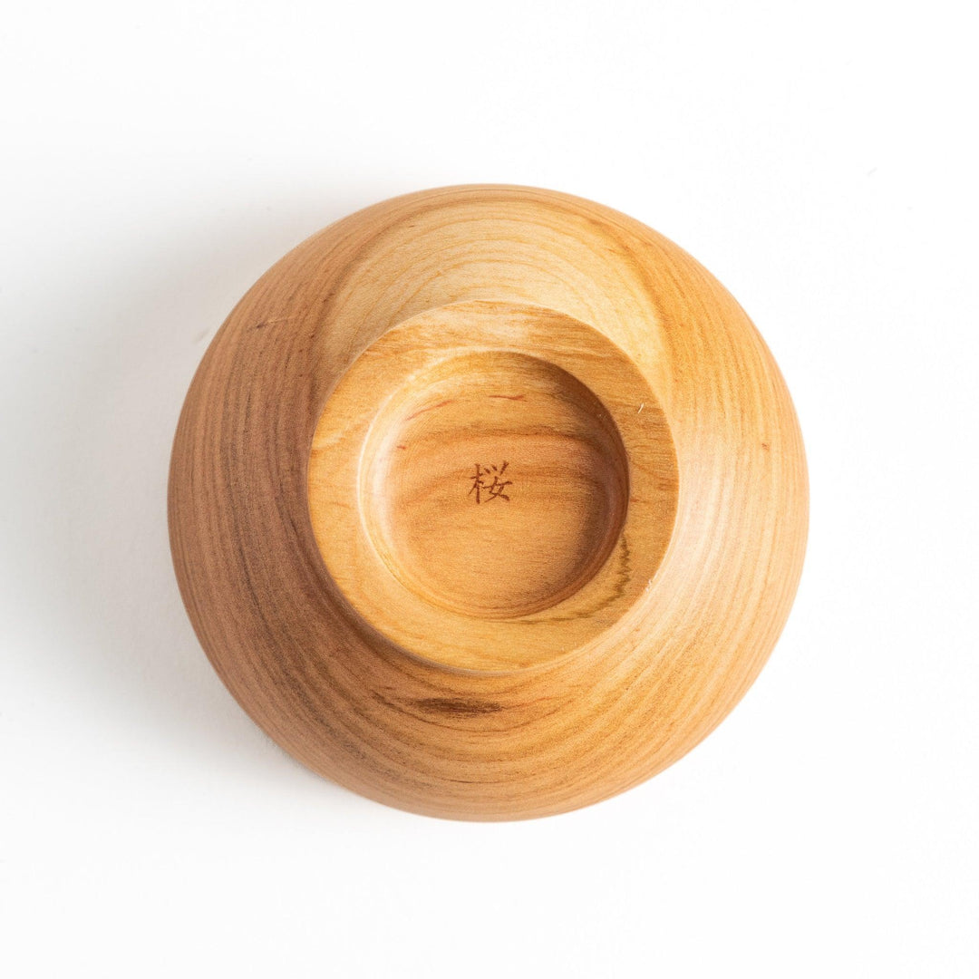 Base view of the wooden bowl revealing intricate craftsmanship and a unique mark, perfect for collectors and chefs.