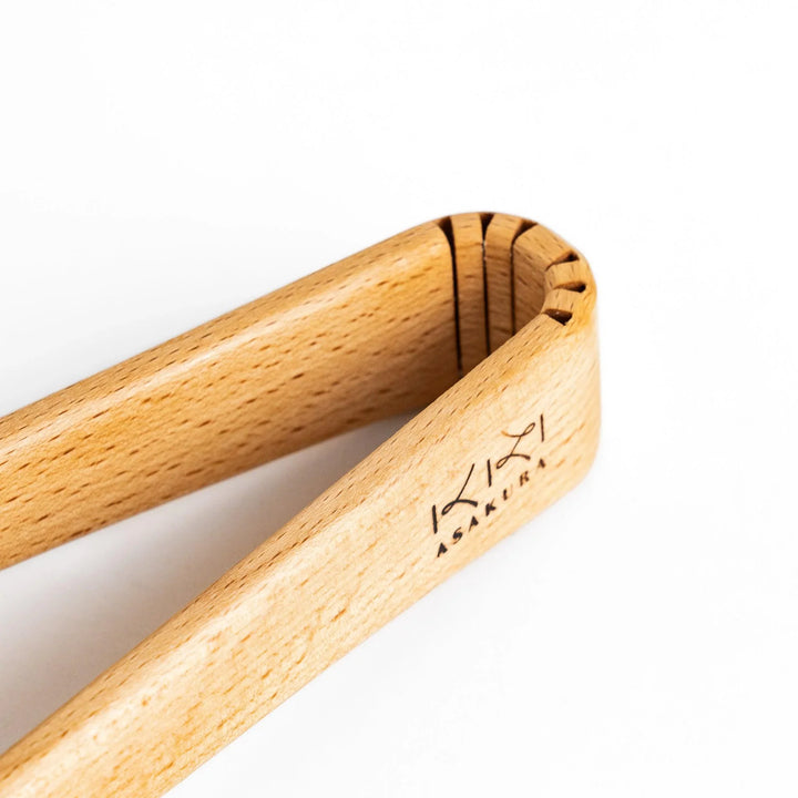 Handcrafted wooden tongs with a smooth surface and angled tips, perfect for stylishly serving or handling food.