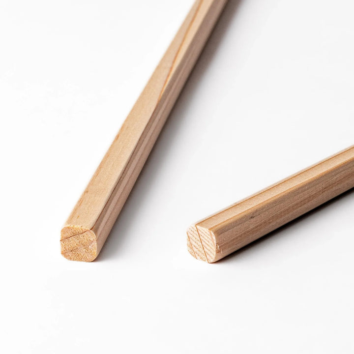 Pair of hinoki wood cooking chopsticks with smooth light wood grain and tapered ends, ideal for Japanese cuisine