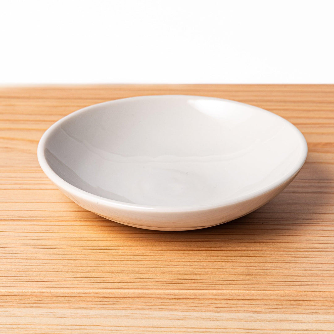 White ceramic dipping dish on hinoki wood sushi plate, showcasing glossy finish and smooth wood grain for sushi service