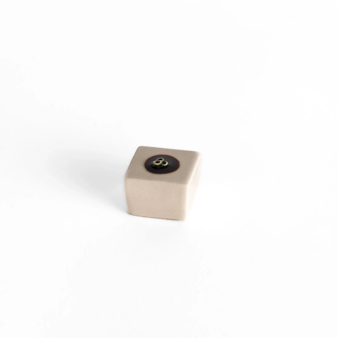 Ceramic tofu chopstick rest shaped like hiyayakko block with beige cube and decorative circular detail.
