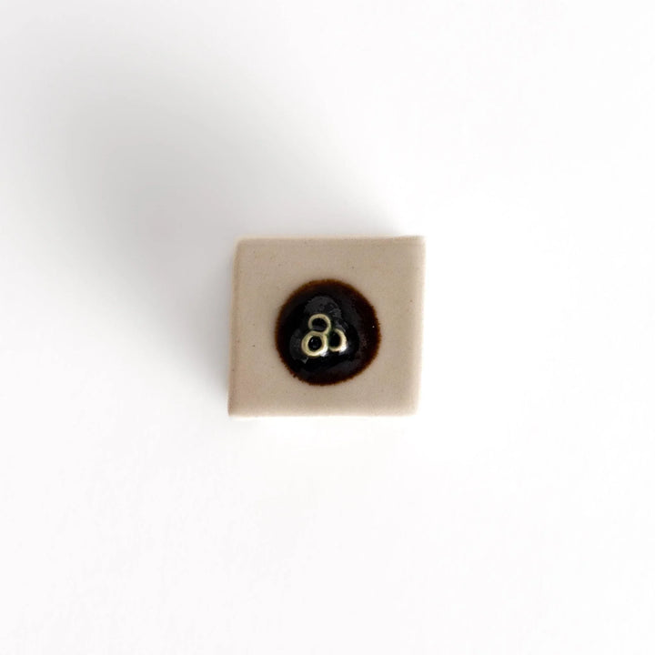 Ceramic tofu chopstick rest shaped like hiyayakko block with beige cube and decorative circular detail.