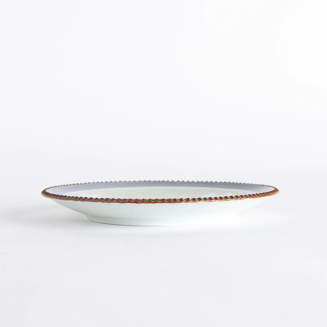 A round salad plate with the famous blue wave design, framed by a textured rim, inspired by Hokusai’s iconic art.