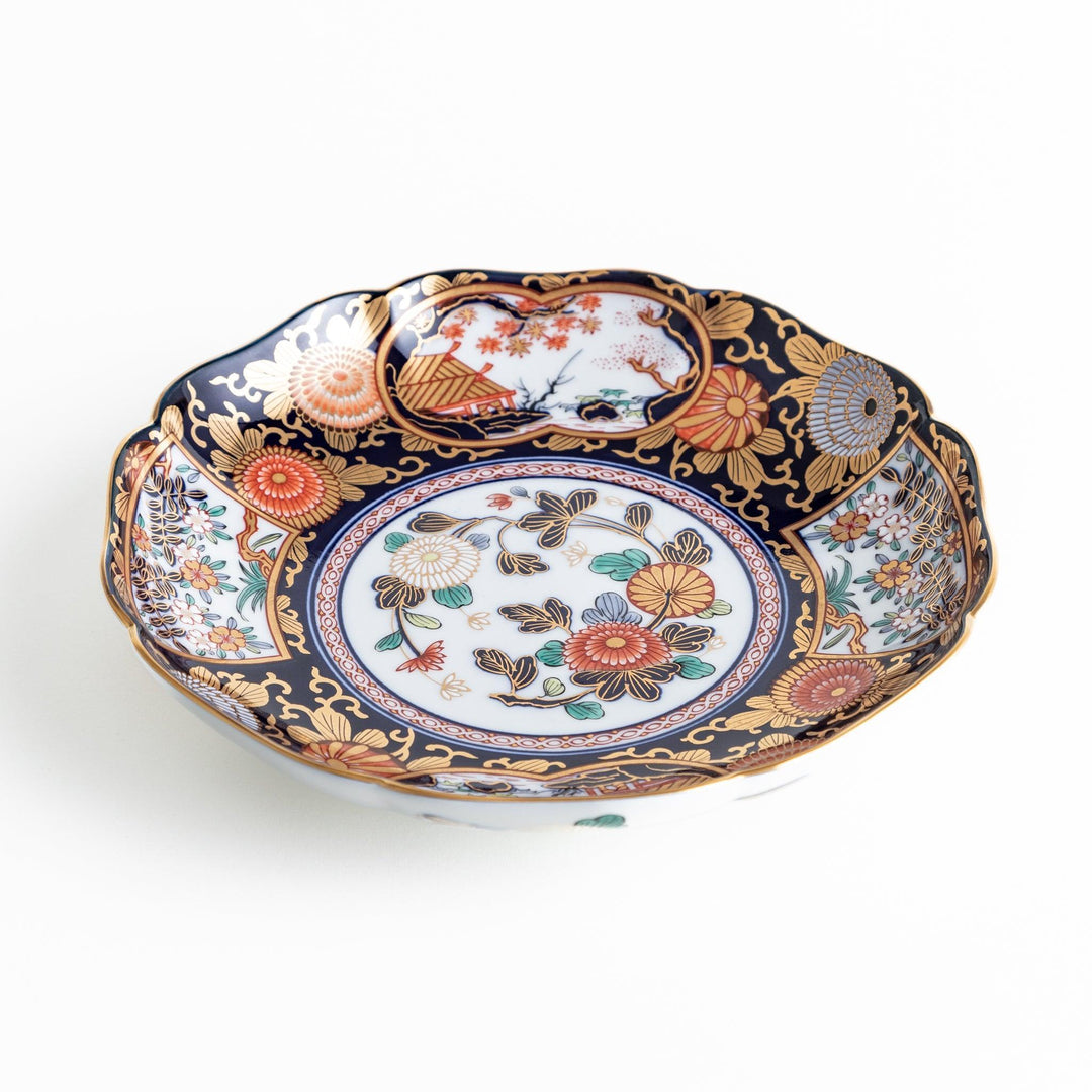 Deep round luncheon plate with dark blue background floral center gold accents and scenic floral border.