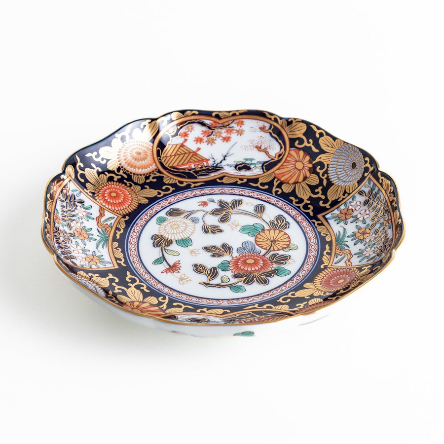 Deep round luncheon plate with dark blue background floral center gold accents and scenic floral border.