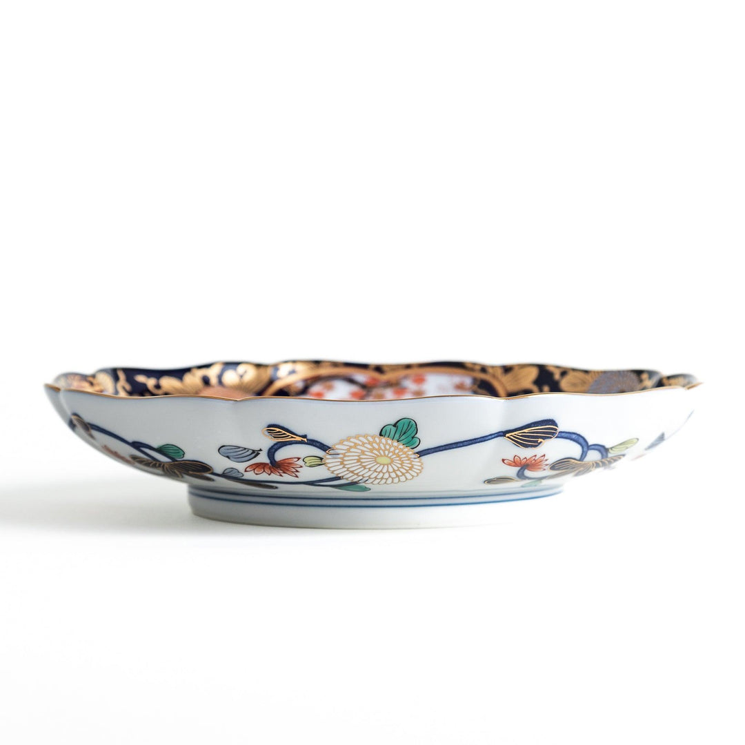 Deep round luncheon plate with dark blue background floral center gold accents and scenic floral border.