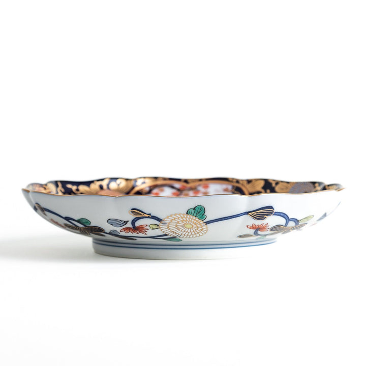 Deep round luncheon plate with dark blue background floral center gold accents and scenic floral border.