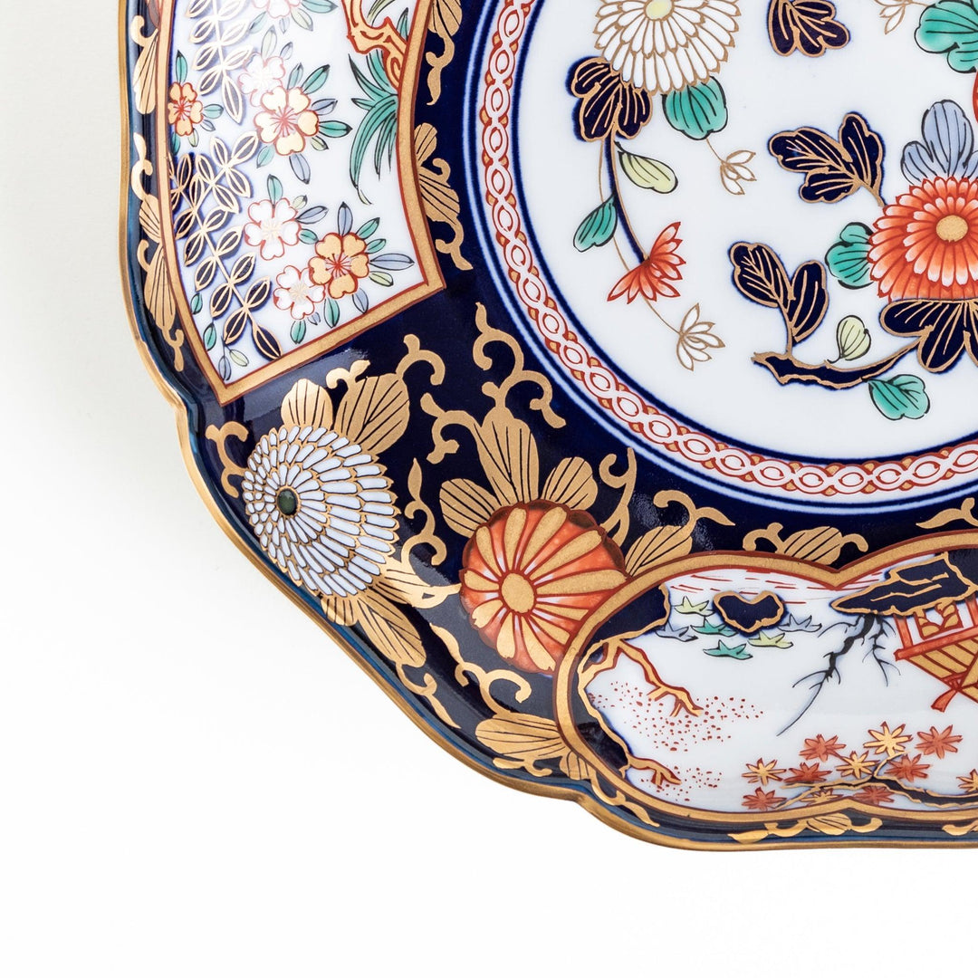 Deep round luncheon plate with dark blue background floral center gold accents and scenic floral border.