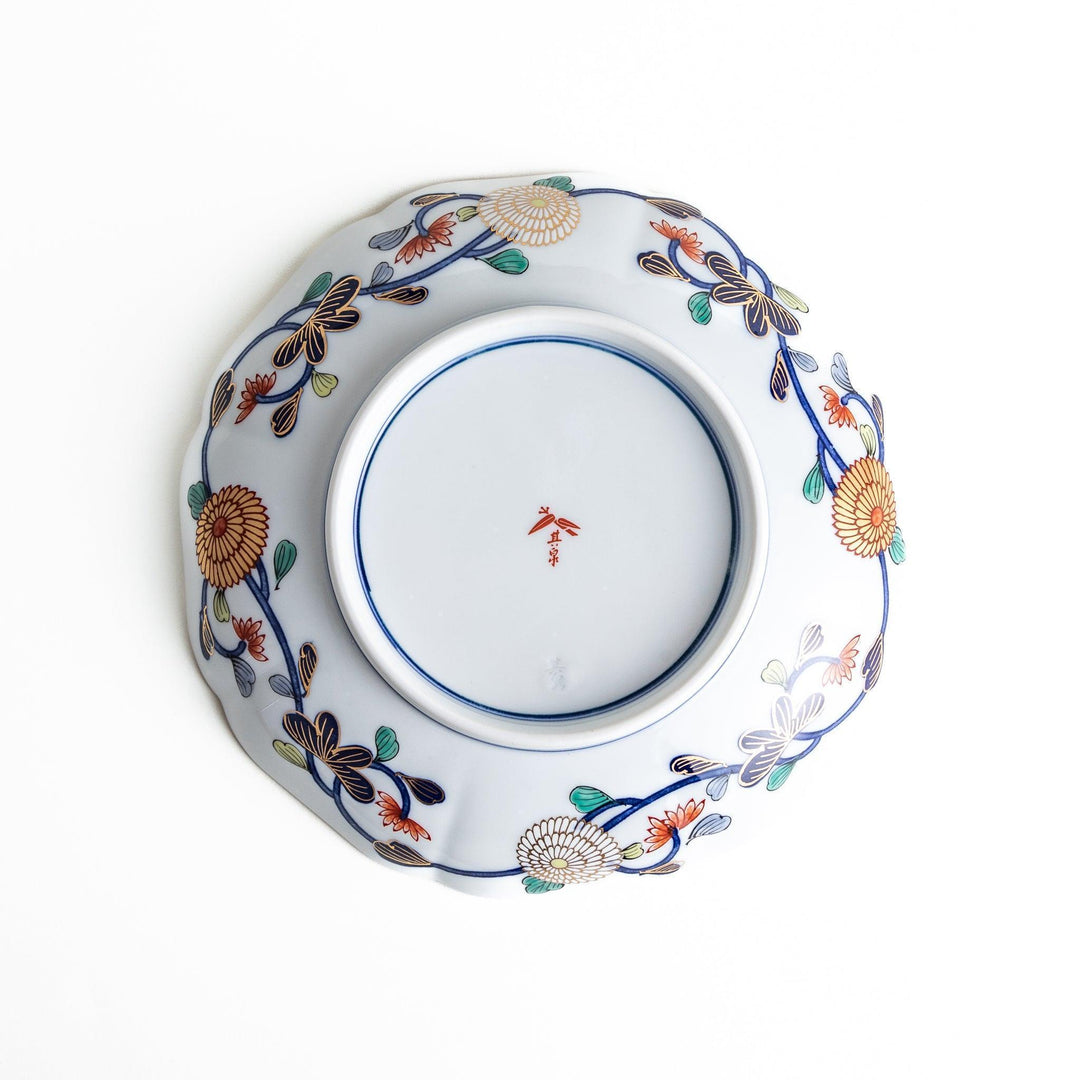 Deep round luncheon plate with dark blue background floral center gold accents and scenic floral border.