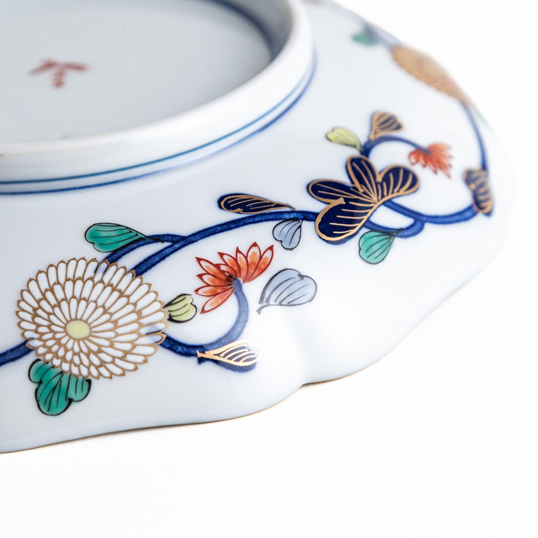 Deep round luncheon plate with dark blue background floral center gold accents and scenic floral border.