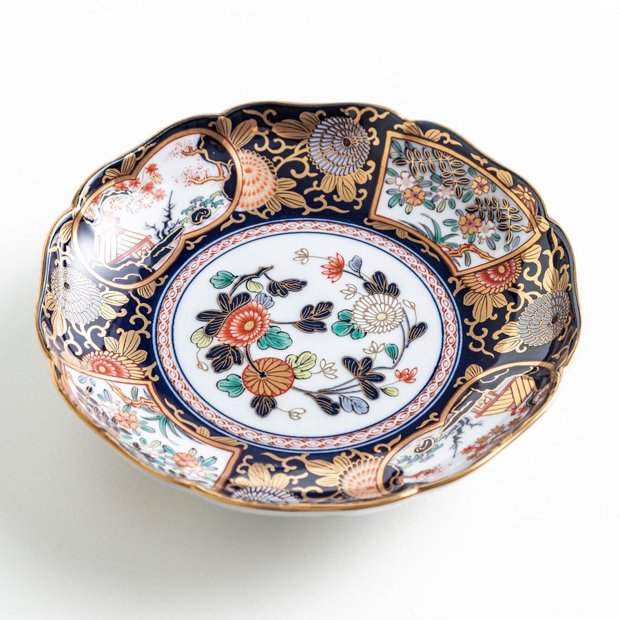 Deep round salad plate with dark blue background floral center and gold red designs of Japanese scenery.