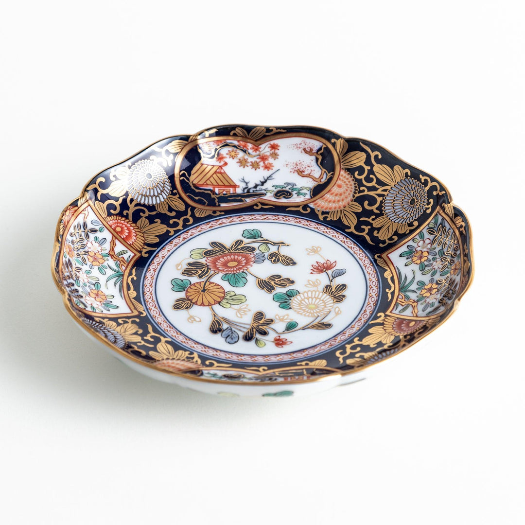 Deep round salad plate with dark blue background floral center and gold red designs of Japanese scenery.