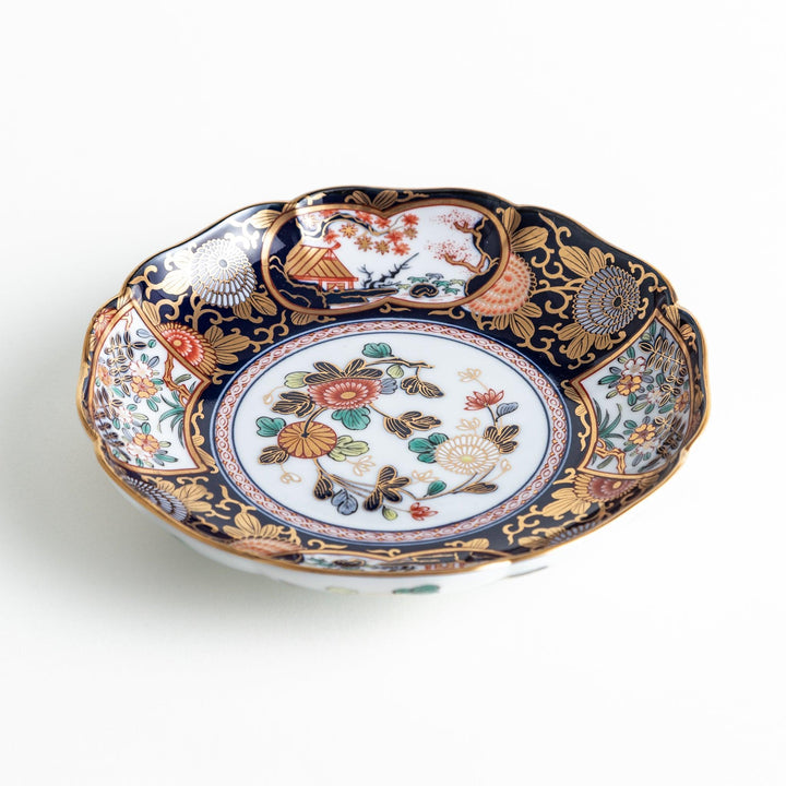 Deep round salad plate with dark blue background floral center and gold red designs of Japanese scenery.