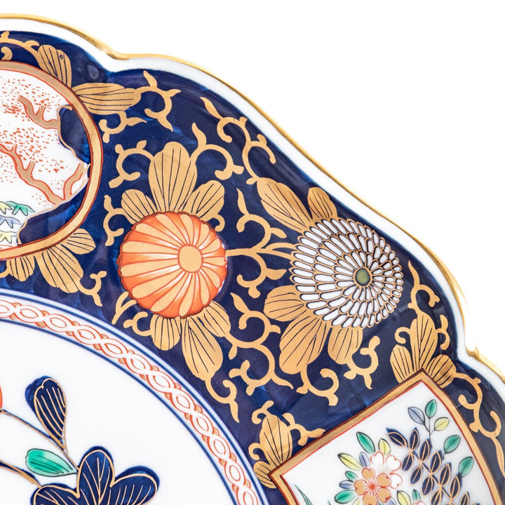 Japanese porcelain serving plate with chrysanthemum and peony motifs in vivid colors and gold detailing on a deep navy base