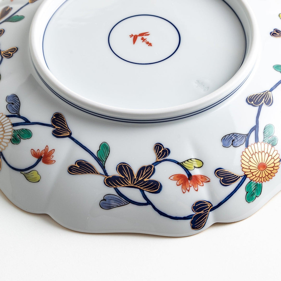 Japanese porcelain serving plate with chrysanthemum and peony motifs in vivid colors and gold detailing on a deep navy base