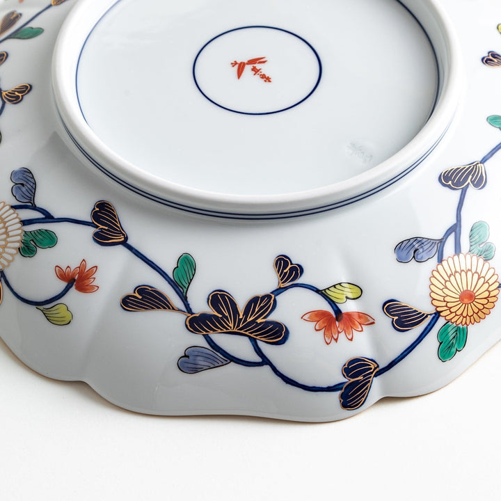 Japanese porcelain serving plate with chrysanthemum and peony motifs in vivid colors and gold detailing on a deep navy base