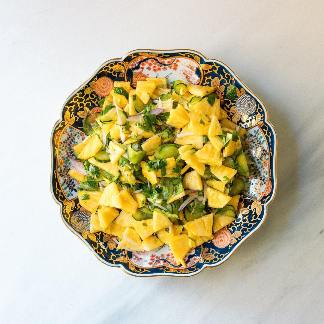 Japanese porcelain serving plate with chrysanthemum and peony motifs in vivid colors and gold detailing on a deep navy base