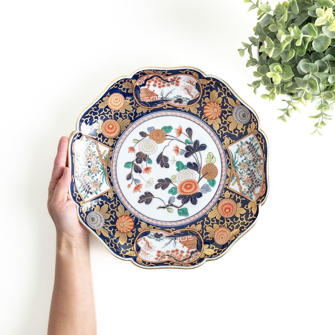 Japanese porcelain serving plate with chrysanthemum and peony motifs in vivid colors and gold detailing on a deep navy base