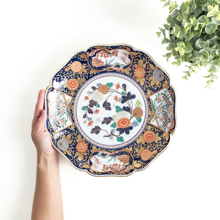 Japanese porcelain serving plate with chrysanthemum and peony motifs in vivid colors and gold detailing on a deep navy base