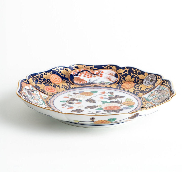 Japanese porcelain serving plate with chrysanthemum and peony motifs in vivid colors and gold detailing on a deep navy base