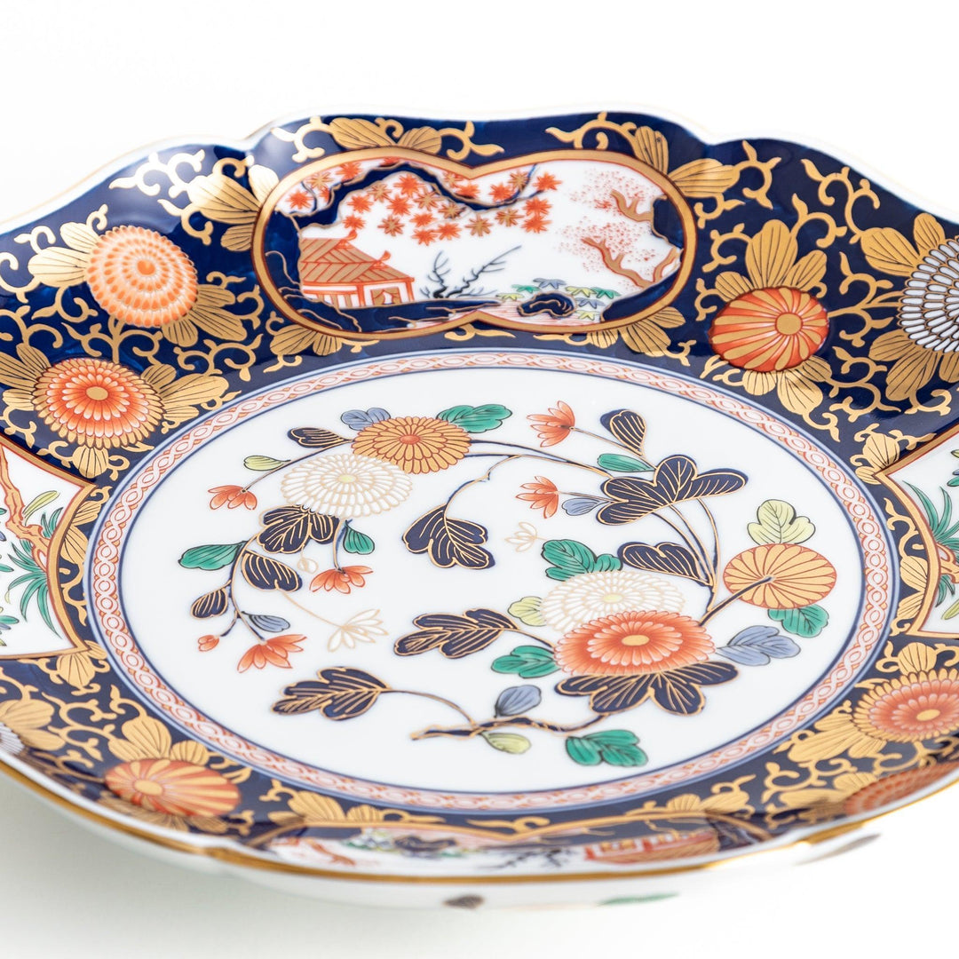 Japanese porcelain serving plate with chrysanthemum and peony motifs in vivid colors and gold detailing on a deep navy base