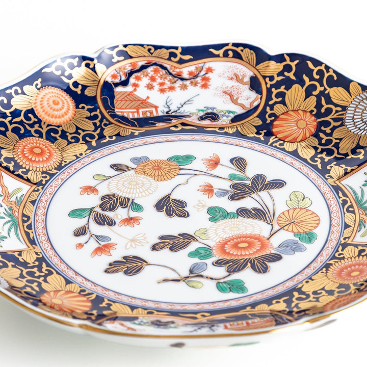 Japanese porcelain serving plate with chrysanthemum and peony motifs in vivid colors and gold detailing on a deep navy base