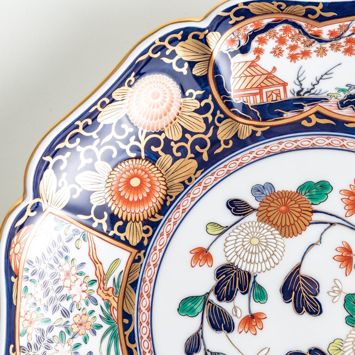Japanese porcelain serving plate with chrysanthemum and peony motifs in vivid colors and gold detailing on a deep navy base